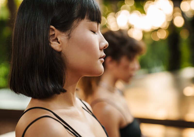 Woman practicing mindfulness meditation with closed eyes in serenity