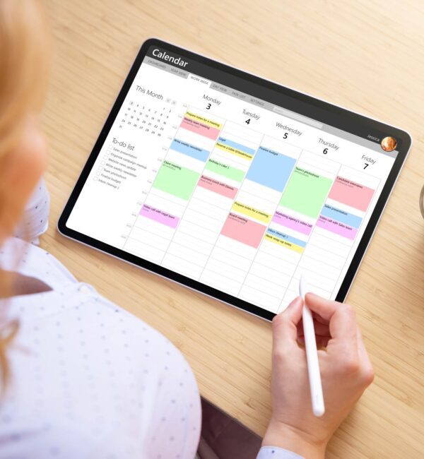 User interacting with a digital planner on iPad using Apple Calendar and stylus for scheduling